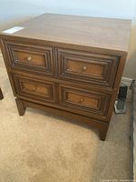Full view of the wooden two drawer side table showing front and top surfaces along with drawer details.