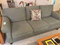 Front view of the three-seat sofa showing overall design and condition