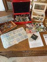 Various jewelry including watches, necklaces, earrings in boxes and cases arranged on a surface