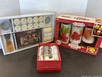 Lot overview showing boxed candle sets and owl plug-in light