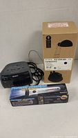 Sony clock radio, IKEA Espressivo lamp box, Forever Flashlight box grouped on table