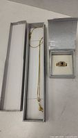 Both necklace and ring displayed in jewelry boxes