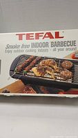 Close up of the Tefal box front showing the product name and image of the indoor BBQ with food on the grill.