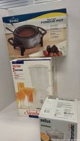 Photo showing boxes of Rival electric fondue pot, Sunbeam 2-speed blender, and Braun Citromatic juicer
