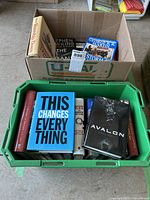 View of a cardboard box containing hardcover books including works by Stephen King and other authors