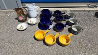 Photo showing all ceramic kitchenware items laid out, including crocks, mugs, plates, and jug.