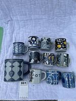 Overview of 10 Royal Copenhagen cups and mug arranged on white cloth