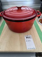 Red Presidents Choice enameled cast iron dutch oven closed with the lid on, showing the pot's full body with side handles and lid's metal knob.