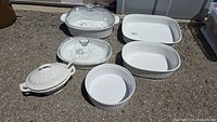 All items in the lot displayed on concrete surface: Royal Crownford Ironstone tureen, under plate, ladle and four Corning French White casserole dishes with lids visible on some items.