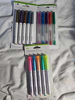 Three packs of Cricut pens and markers visible, showing the various sets together on a light background.