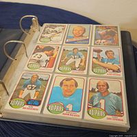 Image of vintage Miami Dolphins football cards in plastic sleeve showing players Garo Yepremian, Norm Evans, Nick Buoniconti, Bob Griese, Norm Bulaich, Bob Kuechenberg.