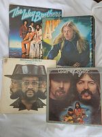Four vintage vinyl record albums including The Isley Brothers, Billy Paul, Eagles, and another group.