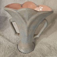 Front and side view of the Mid Century pottery vase exhibiting flared scalloped rim, two handles, and pastel glaze