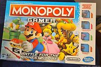 Front view of Monopoly Gamer Mario Bros edition board game box showing colorful character artwork and branding.