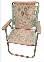 Front view of the vintage aluminum lawn chair showing woven green and beige pattern, armrests, and frame