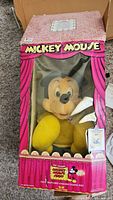 Photo showing the vintage Mickey Mouse plush in original pink box with plastic window and visible box damage.