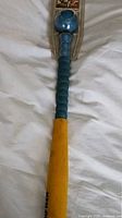 Blue and yellow plastic baseball bat showing the full length and wear detail