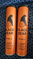 Front view of two vintage Black Bear Co. orange grease tubes, 14 oz each, with black bear logo and MP No. 2 labeling.