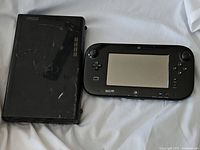 Nintendo Wii U console and GamePad controller placed on white fabric background, showing overall condition and scale.