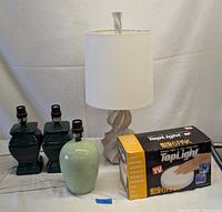 Lot of three ceramic table lamp bases (two dark green, one light green), one beige table lamp with twisted wooden base and fabric shade, plus boxed TapLight sensor light 6-pack.