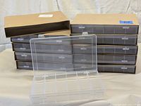 Stack of 10 clear plastic storage boxes with hinged tops shown in packaging and stacked