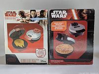 Front view of the boxes showing the Millennium Falcon and Death Star waffle makers. Both boxes feature images of the waffle makers and waffles shaped as the Millennium Falcon and Death Star respectively.