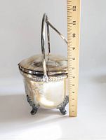 Side view of vintage ice bucket with handle upright, showing a measuring stick indicating about 12 inches tall with handle, over 6.75 inches without.
