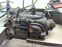 Close-up of Singer 246-3 sewing machine showing machine body, adjustment knobs, oil window, and power cord.