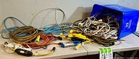 Overview of the extension cords spread on a table with a blue bin containing additional cords and power strips