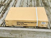 Cardboard box with printed label indicating 500kg motorcycle mini lift, product PO 173709, made in China.