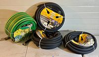 All four hoses arranged on a table showing three black Swan hoses and one green hose