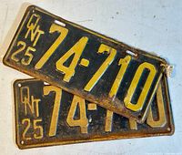 Pair of 1925 Ontario metal license plates with black and yellow coloring, numbers 74-710, front side.