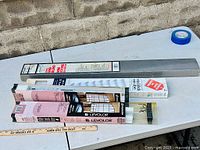 Four packages of new window blinds laid out on table showing original packaging and size labels