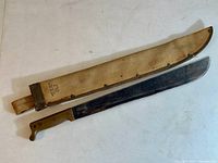 Machete and sheath laid flat showing full length and blade.