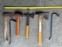 Full view of six hand tools aligned horizontally with measuring tape showing approximately 27 inches in length.