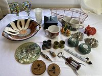 Full overview of lot contents including bowl, basket, mugs, wine goblets, decorative items, and small kitchen accessories
