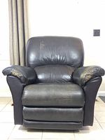 Front view of brown leather Lay-Z-Boy recliner showing cushioned seat, backrest, and arms with visible wear on leather surface.