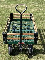 Front view of Millside Industries metal wagon on grass, showing wooden side rails and mesh floor.
