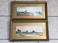 Top and bottom views of two framed watercolour landscape paintings on the floor