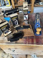 Overview of all items showing Veritas Variable Burnisher, Jointer & Edger in box, Scraper Holder in box, and No 4 hand plane on wood bench