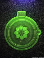 Top view under UV light revealing the bright glowing yellow-green Vaseline glass and the Federal mark on handle tab.