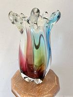 Front angled view of Murano art glass vase showing rainbow colors and fluted top edge.
