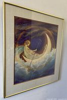 Framed art print featuring an angelic figure in a crescent moon boat surrounded by clouds and stars at night, viewed from an angle.