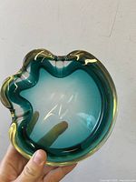 Top view of aqua-turquoise Murano glass ashtray showing irregular wavy organic edge and deep clear aqua colored center.