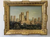 Front view of the vintage Florentine village landscape oil painting housed in an ornate gilded frame.