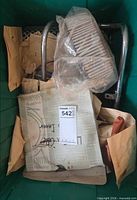 Overall view inside tote showing filter, chrome bracket and packaged parts