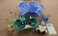 Group shot shows blue ruffled centerpiece, green tri-lobed bowl, clear dolphin, clear mouse, blue bird and clown figurines