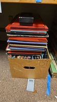 Box holding stack of loose vintage game boards