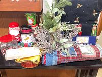 Overall lot showing pillow, tins, vase with greenery, glitter branches, quilted textile and other items
