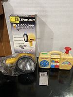Overall lot view with spotlight, carton, toy boom box and MaxSold tag